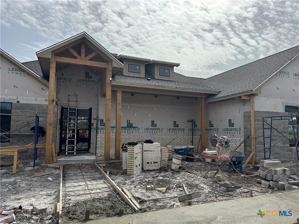 exterior space with roof with shingles and fence