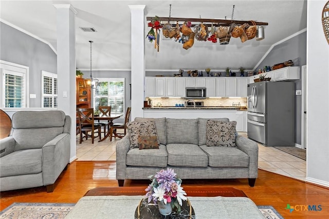 living room with lofted ceiling, ornamental molding, ornate columns, and light tile patterned flooring