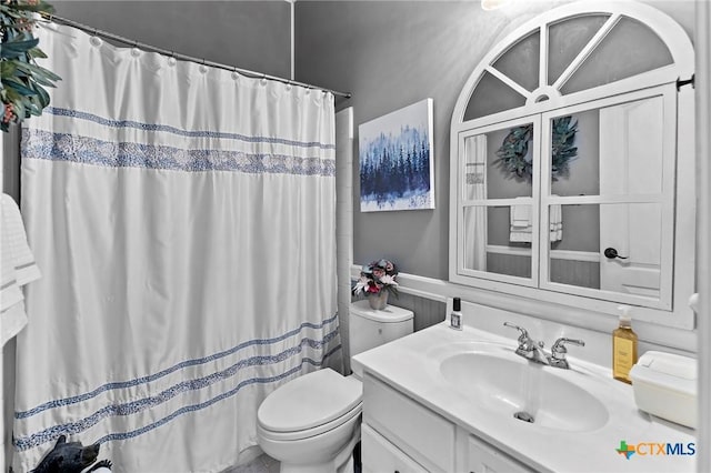 bathroom featuring vanity, toilet, and a shower with shower curtain