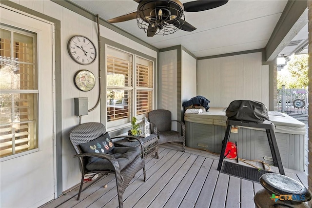 deck featuring ceiling fan and a hot tub