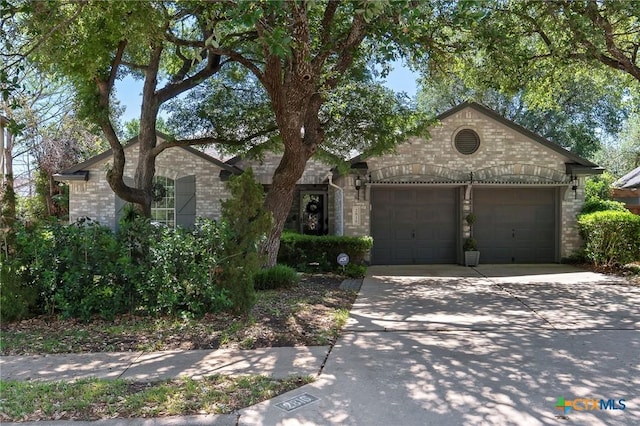 view of front facade with an attached garage, driveway, and brick siding