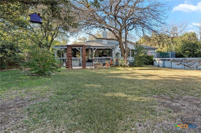 view of yard with a swimming pool with hot tub and a pergola