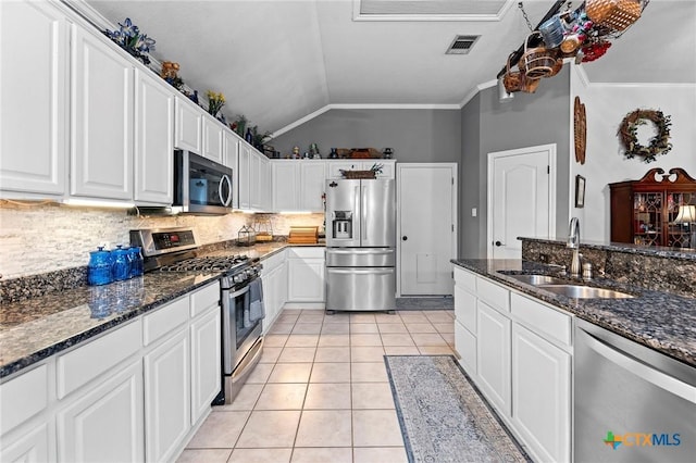 kitchen featuring white cabinetry, sink, lofted ceiling, and appliances with stainless steel finishes