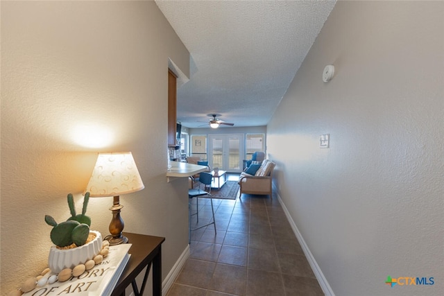 hall featuring french doors and dark tile patterned flooring