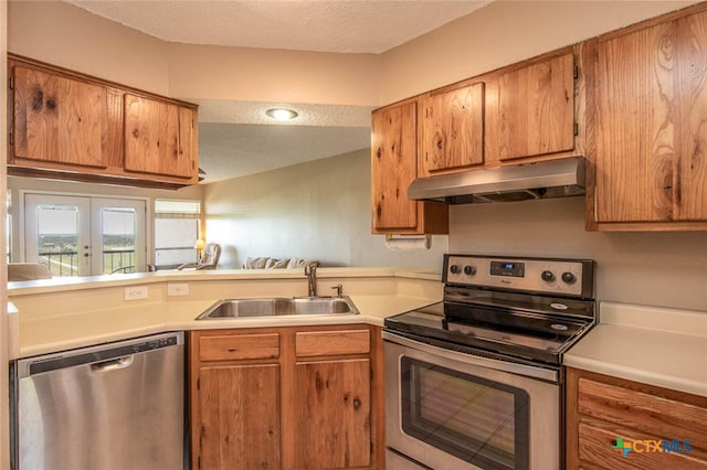 kitchen featuring a textured ceiling, stainless steel appliances, and sink