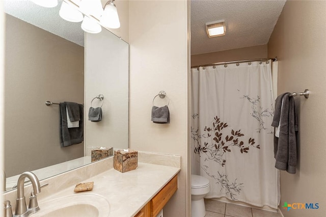 bathroom featuring toilet, vanity, a textured ceiling, and tile patterned floors