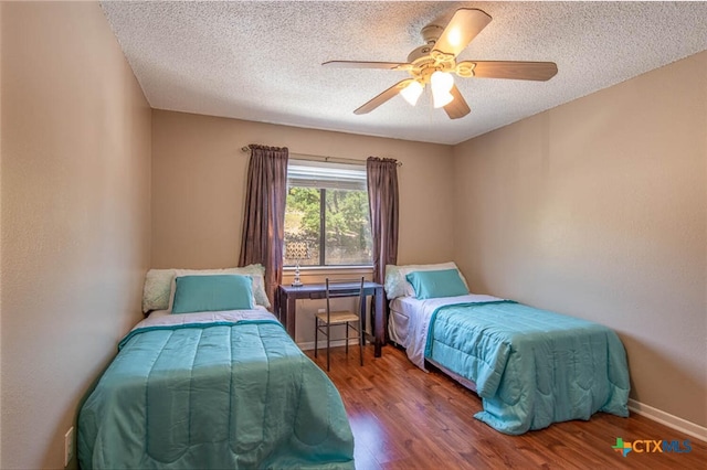 bedroom with hardwood / wood-style floors, ceiling fan, and a textured ceiling