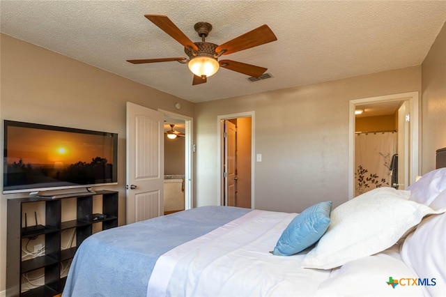 bedroom with a textured ceiling, ceiling fan, and ensuite bath