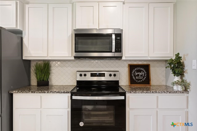 kitchen featuring stainless steel appliances, white cabinets, and dark stone counters