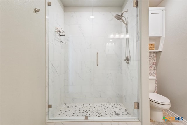 bathroom featuring a shower with door, tile patterned flooring, and toilet