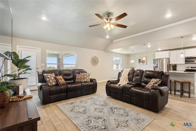 living room featuring light hardwood / wood-style floors, ceiling fan, vaulted ceiling, and ornamental molding