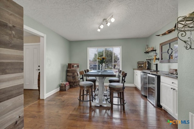 dining area featuring dark wood-style floors, wine cooler, baseboards, and a dry bar