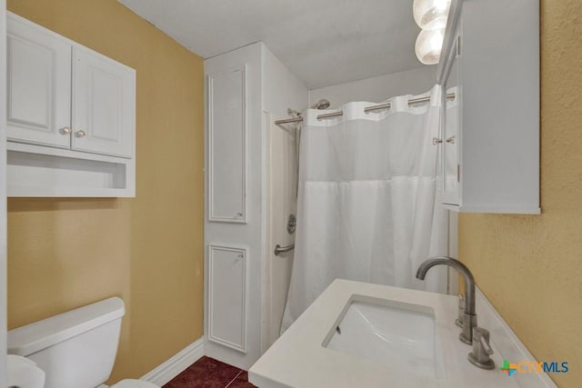 full bathroom featuring toilet, a shower with shower curtain, a sink, baseboards, and tile patterned floors