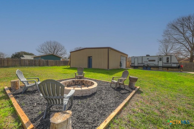 view of yard featuring a pole building, an outdoor fire pit, an outdoor structure, and fence