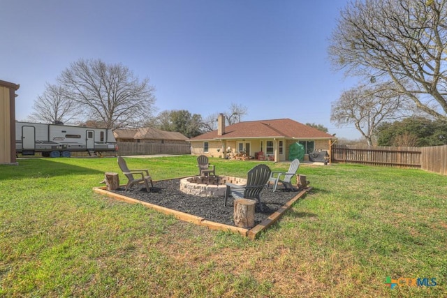 view of yard featuring a fenced backyard and a fire pit