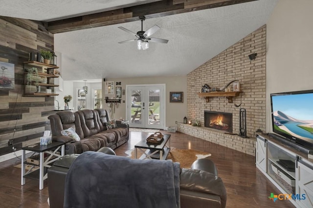 living area featuring a textured ceiling, a fireplace, wood finished floors, french doors, and beamed ceiling