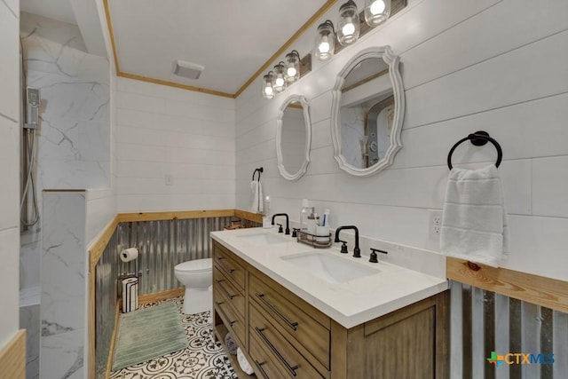 bathroom with double vanity, a sink, toilet, and crown molding