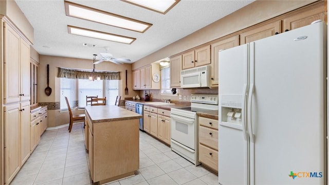 kitchen with a center island, light brown cabinetry, light tile patterned floors, white appliances, and a sink