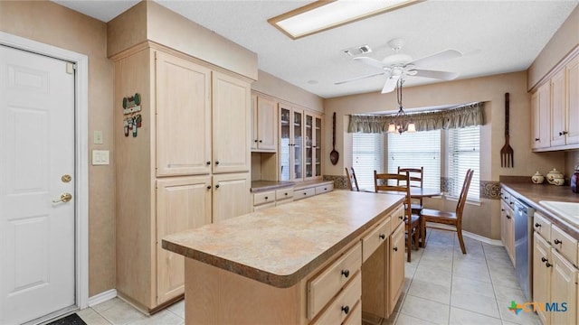 kitchen with visible vents, light brown cabinets, a kitchen island, ceiling fan, and stainless steel dishwasher