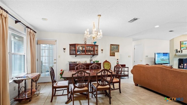 dining room featuring light tile patterned flooring, visible vents, a textured ceiling, and an inviting chandelier