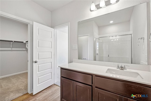 bathroom featuring walk in shower, vanity, and hardwood / wood-style floors