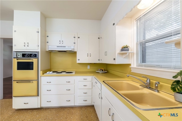 kitchen featuring white cabinets, white gas stovetop, and sink