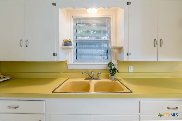 kitchen featuring white cabinets and sink