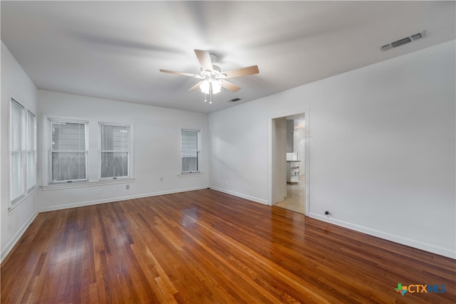 spare room featuring dark wood-type flooring and ceiling fan