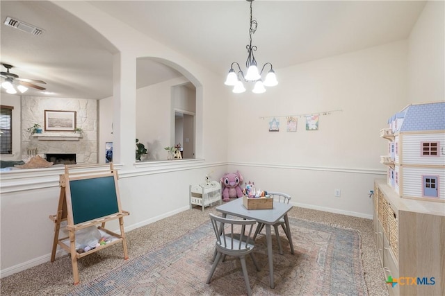 recreation room featuring ceiling fan, a stone fireplace, and carpet floors