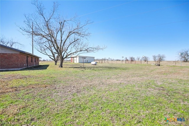 view of yard with a rural view and an outdoor structure