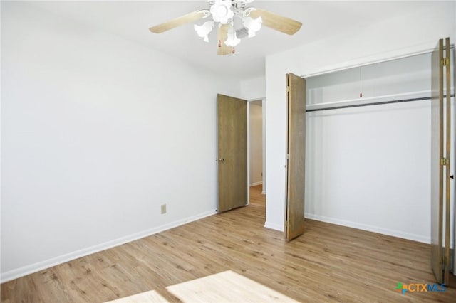 unfurnished bedroom with a closet, wood finished floors, a ceiling fan, and baseboards