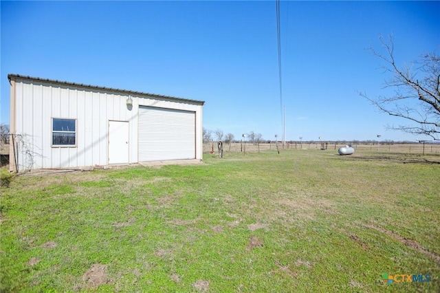 view of yard with an outbuilding, fence, and a garage