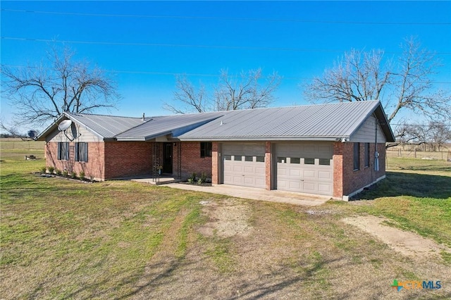 view of front of house with dirt driveway, metal roof, a front lawn, and brick siding