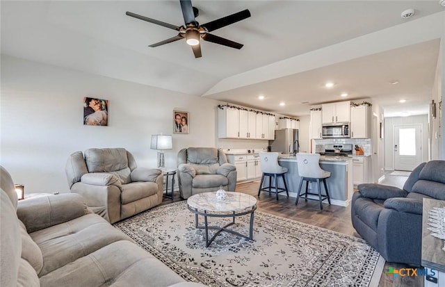 living room with lofted ceiling, wood-type flooring, and ceiling fan