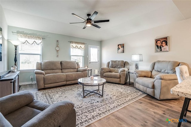 living room featuring wood-type flooring and ceiling fan