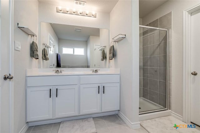 bathroom with tile patterned flooring, vanity, and an enclosed shower