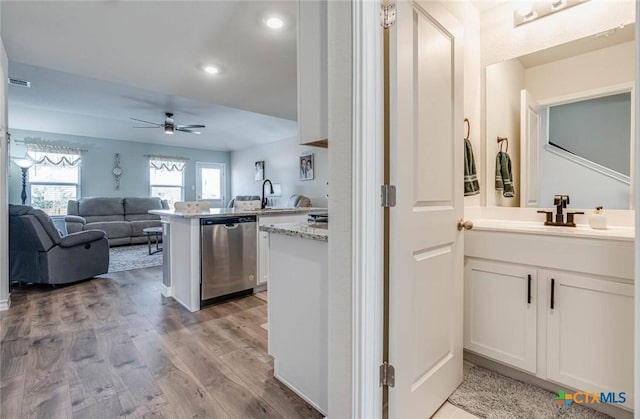 kitchen with sink, dishwasher, light hardwood / wood-style floors, white cabinets, and kitchen peninsula