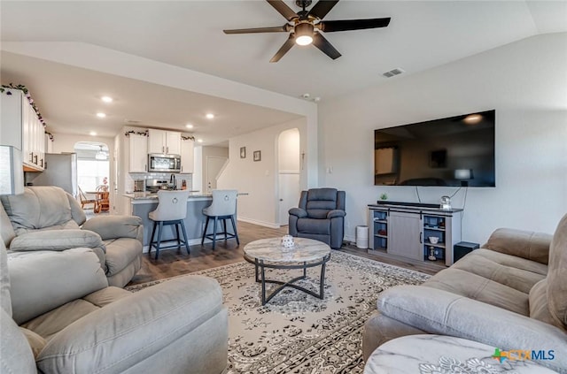 living room with hardwood / wood-style flooring, vaulted ceiling, and ceiling fan