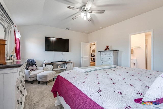 bedroom with ceiling fan, light colored carpet, ensuite bathroom, and vaulted ceiling