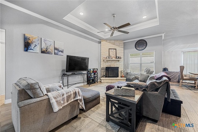 1211 Liberation Ln, Copperas Cove, TX 76522 - living room with a tray ceiling, crown molding, a ceiling fan, a fireplace, and wood finished floors