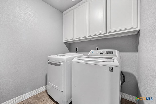 1211 Liberation Ln, Copperas Cove, TX 76522 - laundry room with cabinet space, separate washer and dryer, and light wood-style floors