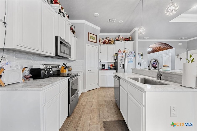 1211 Liberation Ln, Copperas Cove, TX 76522 - kitchen featuring stainless steel appliances, ornamental molding, a kitchen island with sink, light wood-style floors, and white cabinets