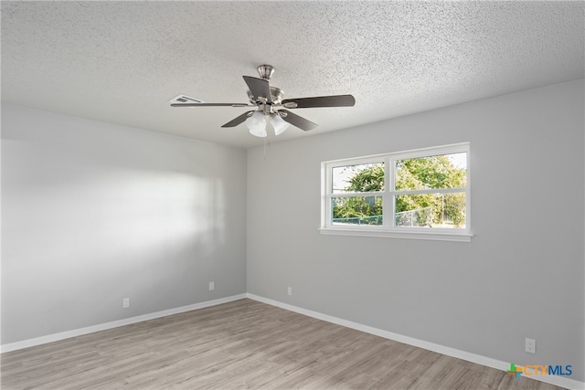 spare room with light hardwood / wood-style floors, a textured ceiling, and ceiling fan