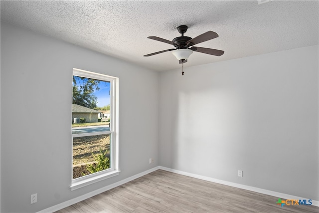 unfurnished room featuring ceiling fan, a textured ceiling, and light wood-type flooring