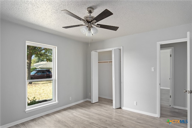 unfurnished bedroom featuring a textured ceiling, light hardwood / wood-style flooring, and ceiling fan