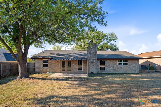 back of property featuring a patio area and a lawn