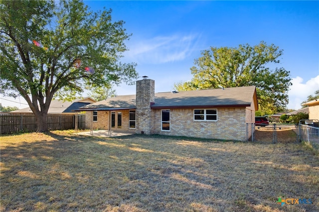 back of house featuring a lawn