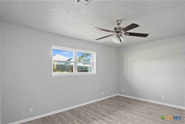 spare room featuring light hardwood / wood-style floors, ceiling fan, and a textured ceiling