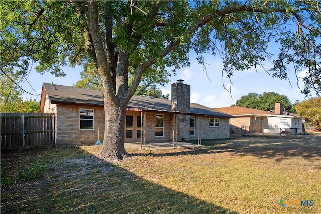 back of property with a patio and a yard