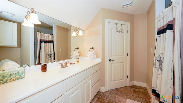 bathroom featuring vanity, baseboards, and stone finish flooring